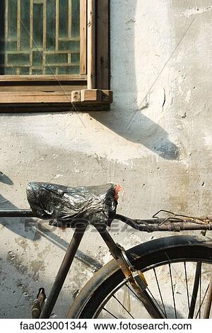 Bicycle with plastic bag covering seat, cropped view View Large Photo Image Picture - Bicycle with plastic bag covering seat, cropped view. Fotosearch