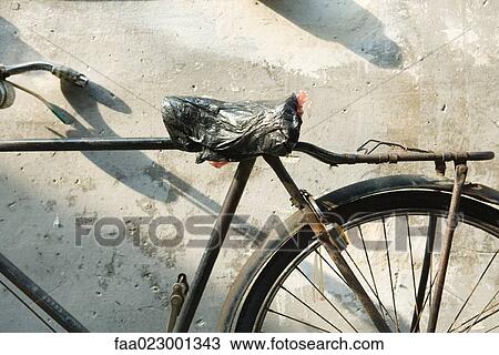 Bicycle with plastic bag covering seat, cropped view View Large Photo Image Stock Image - Bicycle with plastic bag covering seat, cropped view. Fotosearch