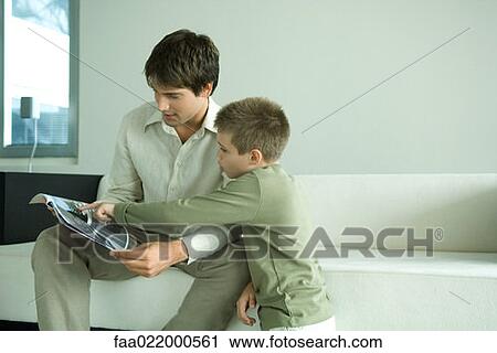 Boy and father looking at magazine together View Large Photo Image Stock Image - Boy and father looking at magazine together. Fotosearch