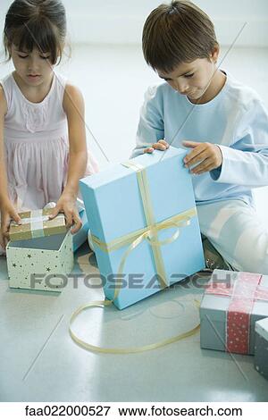 Stock Photo - Boy and girl opening presents. Fotosearch