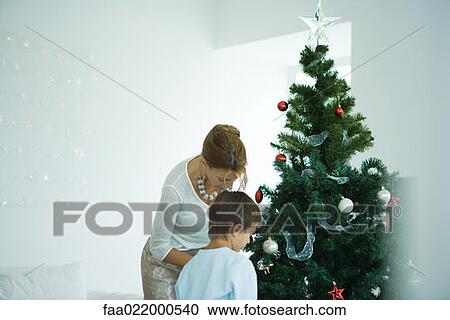 Boy and mother decorating Christmas tree View Large Photo Image Stock Image - Boy and mother decorating Christmas tree. Fotosearch