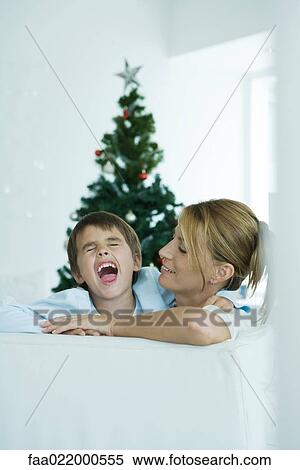 Boy and mother on sofa, boy screaming, Christmas tree in background View Large Photo Image Stock Photography - Boy and mother on sofa, boy screaming, Christmas tree in background. Fotosearch