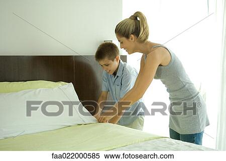 Boy helping mother make bed View Large Photo Image Stock Photography - Boy helping mother make bed. Fotosearch