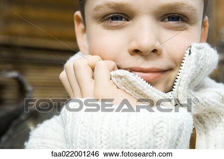 Boy holding collar of wool sweater over face, smiling at camera, close-up, portrait View Large Photo Image Stock Photograph - Boy holding collar of wool sweater over face, smiling at camera, close-up, portrait. Fotosearch