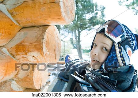 Boy holding skis on shoulder, smiling over shoulder at camera View Large Photo Image Stock Photograph - Boy holding skis on shoulder, smiling over shoulder at camera. Fotosearch