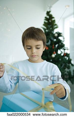 Boy opening Christmas presents View Large Photo Image Picture - Boy opening Christmas presents. Fotosearch