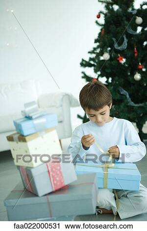 Boy opening Christmas presents View Large Photo Image Stock Image - Boy opening Christmas presents. Fotosearch