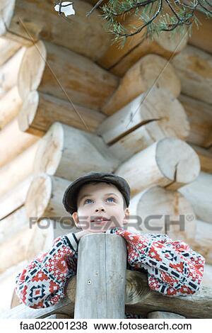 Boy standing on deck of wood cabin, leaning on rail View Large Photo Image Stock Photo - Boy standing on deck of wood cabin, leaning on rail. Fotosearch