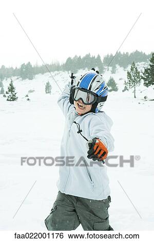 Stock Photograph - Boy throwing snowball, dressed in ski clothing, three quarter length. Fotosearch