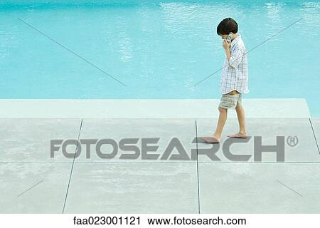 Boy walking next to swimming pool, using cell phone, looking down View Large Photo Image Stock Image - Boy walking next to swimming pool, using cell phone, looking down. Fotosearch