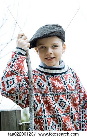 Stock Photo - Boy wearing traditional sweater and cap, holding hiking stick. Fotosearch