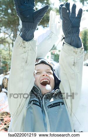 Stock Photo - Boy with arms raised in snow, smiling, eyes closed, head and shoulders. Fotosearch