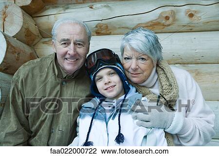 Stock Image - Boy with grandparents, wearing winter clothes, portrait. Fotosearch