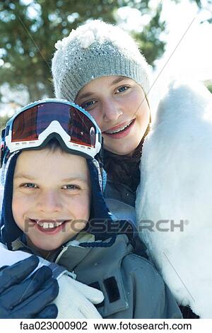 Brother and sister smiling at camera, cheek to cheek, dressed in winter clothing, portrait View Large Photo Image Stock Image - Brother and sister smiling at camera, cheek to cheek, dressed in winter clothing, portrait. Fotosearch