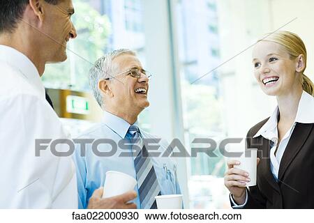 Business associates laughing together, holding hot beverages View Large Photo Image Stock Image - Business associates laughing together, holding hot beverages. Fotosearch