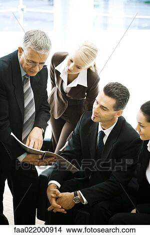 Business associates looking at report together View Large Photo Image Picture - Business associates looking at report together. Fotosearch