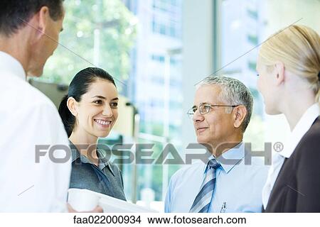Business associates standing together, chatting, head and shoulders View Large Photo Image Picture - Business associates standing together, chatting, head and shoulders. Fotosearch
