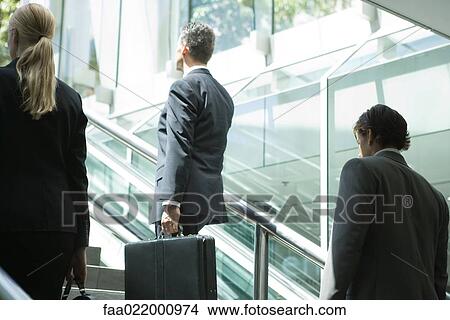 Picture - Business associates walking up stairs, rear view . Fotosearch