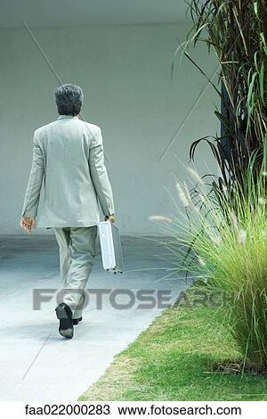 Businessman carrying briefcase, rear view, full length View Large Photo Image Stock Image - Businessman carrying briefcase, rear view, full length. Fotosearch