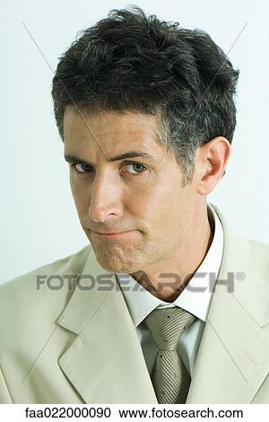 Businessman, lips pursed, looking at camera, portrait View Large Photo Image Stock Image - Businessman, lips pursed, looking at camera, portrait. Fotosearch