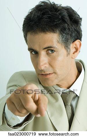 Stock Photo - Businessman pointing at camera, portrait. Fotosearch