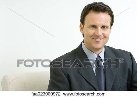Stock Image - Businessman smiling at camera, portrait. Fotosearch
