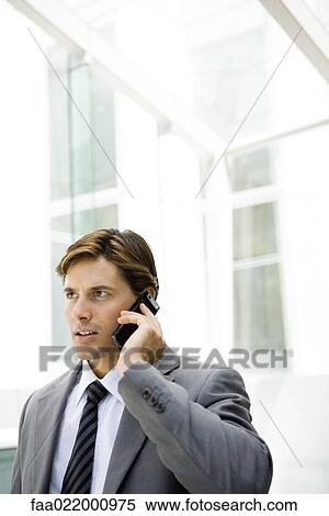 Stock Photography - Businessman using cell phone, looking away, head and shoulders. Fotosearch
