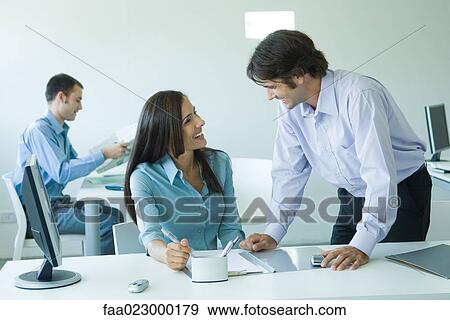 Businesswoman and male colleague laughing together in office View Large Photo Image Stock Photo - Businesswoman and male colleague laughing together in office. Fotosearch