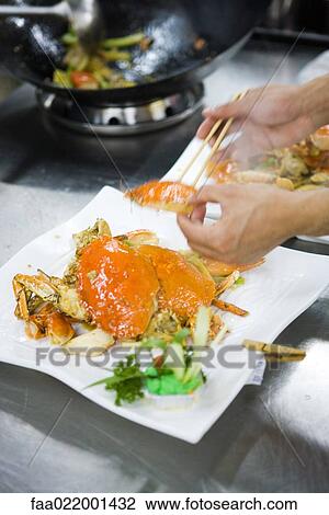 Chef dressing plates in commercial kitchen View Large Photo Image Stock Image - Chef dressing plates in commercial kitchen. Fotosearch