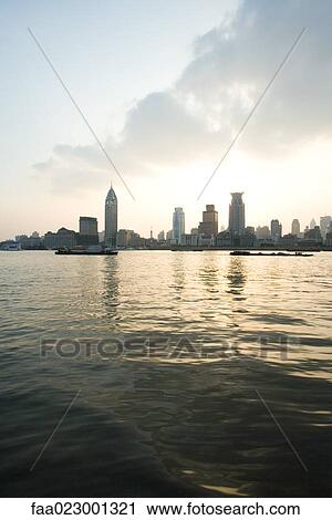 Stock Image - China, Guangdong Province, Guangzhou, view of high rises from lake. Fotosearch