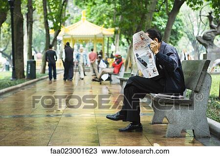 China, Guangdong Province, Guangzhou, man reading newspaper on bench View Large Photo Image Stock Image - China, Guangdong Province, Guangzhou, man reading newspaper on bench. Fotosearch