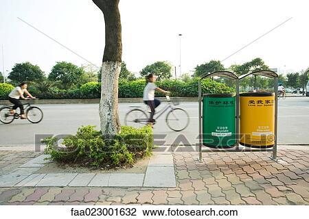 China, Guangdong Province, Guangzhou, cyclists riding in street behind recycling bins View Large Photo Image Stock Image - China, Guangdong Province, Guangzhou, cyclists riding in street behind recycling bins. Fotosearch