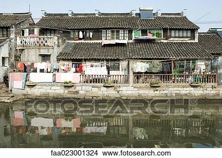 China, Guangdong Province, laundry hanging out in front of houses on edge of water View Large Photo Image Picture - China, Guangdong Province, laundry hanging out in front of houses on edge of water. Fotosearch