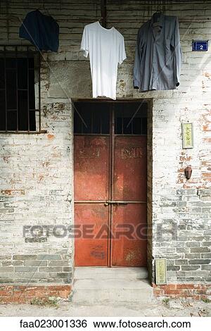Stock Photograph - Clothes hanging to dry over doorway. Fotosearch