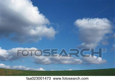 Stock Image - Cloudscape over green field. Fotosearch
