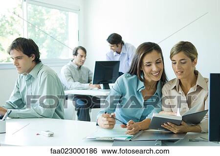Colleagues working together in office View Large Photo Image Stock Photograph - Colleagues working together in office. Fotosearch