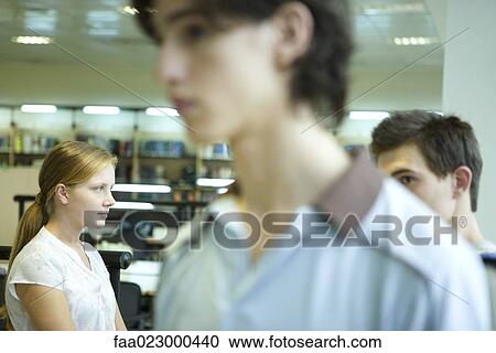 Stock Image - College students in library, candid shot. Fotosearch