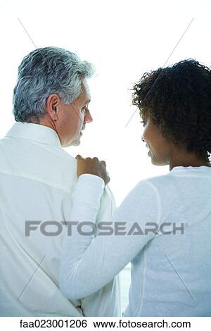 Couple looking at each other, young woman with hand on mature man's shoulder, rear view View Large Photo Image Stock Photograph - Couple looking at each other, young woman with hand on mature man's shoulder, rear view. Fotosearch
