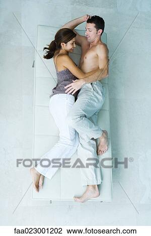 Couple lying on chaise longue together face to face, smiling, full length, view from above View Large Photo Image Stock Image - Couple lying on chaise longue together face to face, smiling, full length, view from above. Fotosearch