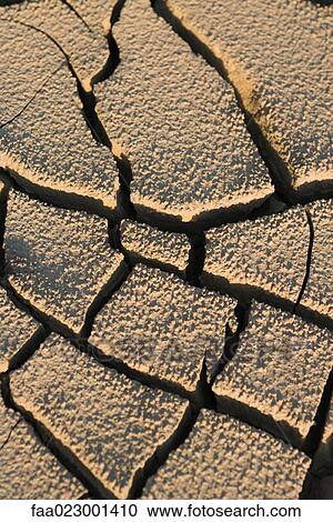 Stock Image - Cracked dry soil, full frame. Fotosearch