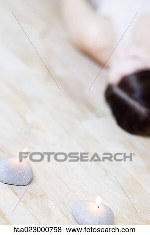 Cropped view of woman lying on floor, defocused, burning candles in foreground View Large Photo Image Stock Photo - Cropped view of woman lying on floor, defocused, burning candles in foreground. Fotosearch