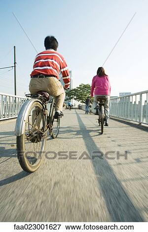 Cyclists crossing bridge, rear view View Large Photo Image Stock Photo - Cyclists crossing bridge, rear view. Fotosearch
