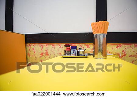 Picture - Diner table with container full of chopsticks. Fotosearch