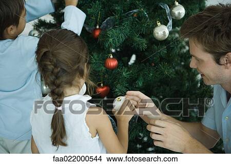 Picture - Family decorating Christmas tree. Fotosearch