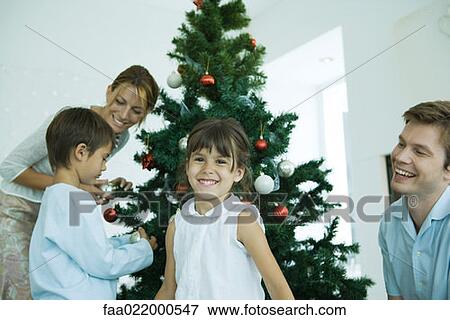 Family decorating Christmas tree View Large Photo Image Stock Photo - Family decorating Christmas tree. Fotosearch