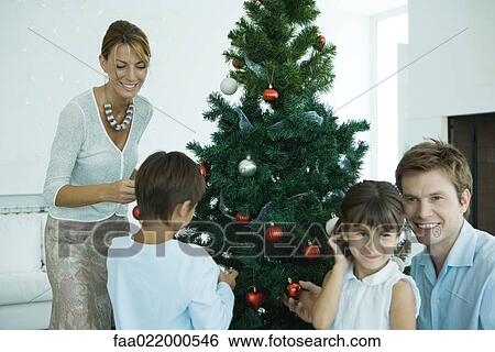 Family decorating Christmas tree View Large Photo Image Stock Photograph - Family decorating Christmas tree. Fotosearch