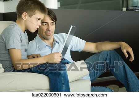 Father and son using laptop together View Large Photo Image Stock Image - Father and son using laptop together. Fotosearch