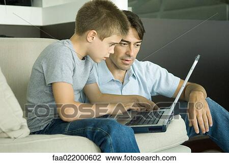 Father and son using laptop together View Large Photo Image Stock Image - Father and son using laptop together. Fotosearch