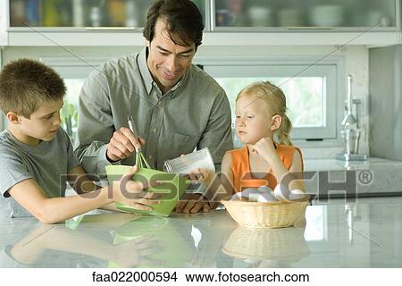 Picture - Father cooking with son and daughter. Fotosearch