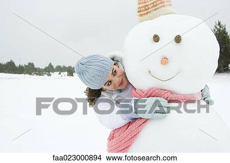 Picture - Female embracing snowman, smiling, portrait. Fotosearch
